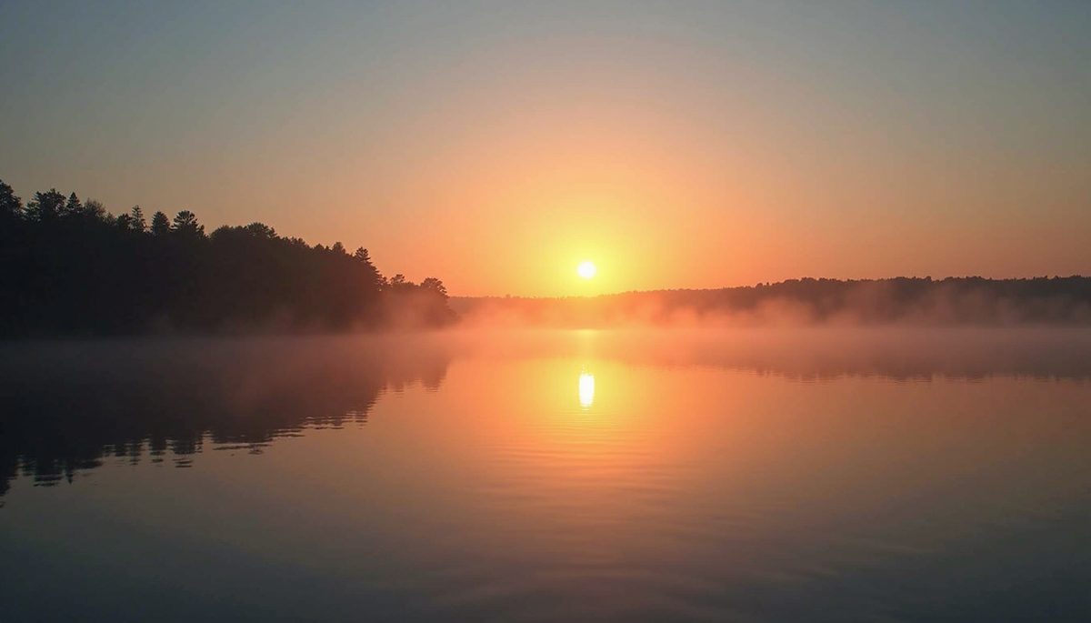 Eye-level view of a serene sunset over a calm lake
